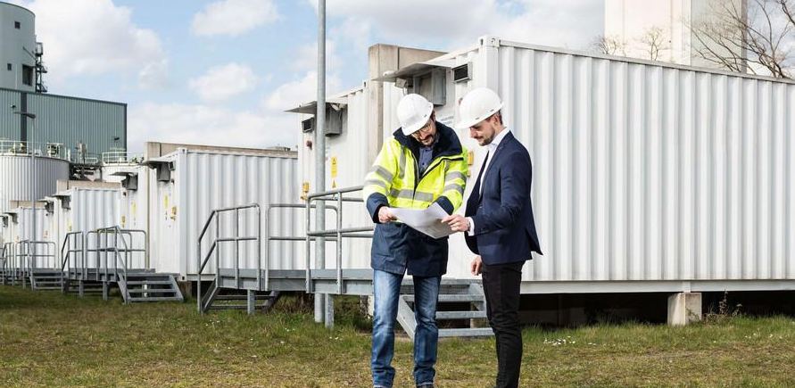 Energy consultants reviewing a battery energy storage project on site